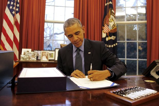 U.S. President Barack Obama signs the $1.1 Trillion Government Funding Bill into Law at the Oval Office of the White House in Washington
