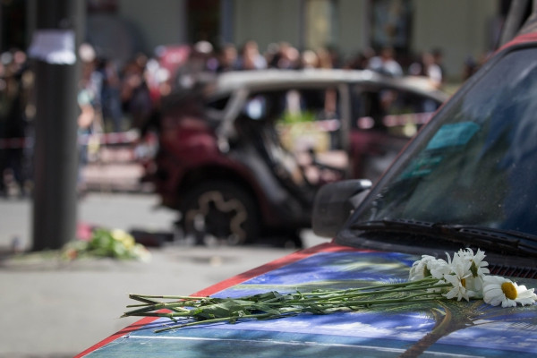 Ukrainians bring flowers to where journalist Pavel Sheremet was killed by a car bomb in the center of Kyiv on July 20, 2016.