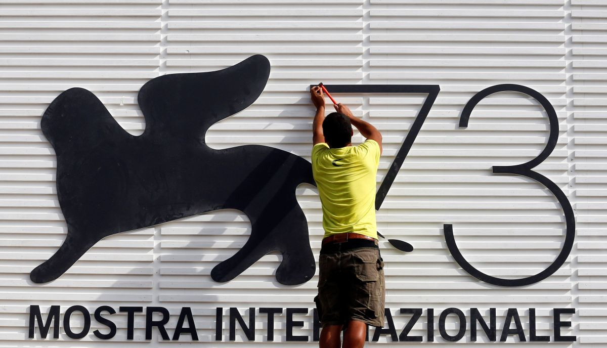 A worker sets a sign before the 73rd Venice Film Festival in Venice