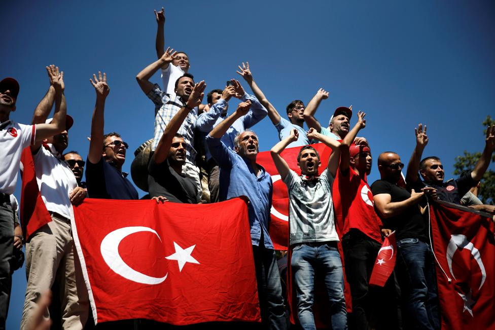 Supporters of Turkish President Tayyip Erdogan shout slogans and wave Turkish national flags during a pro-government demonstration in Sarachane park in Istanbul