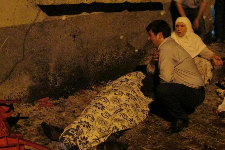 A man and a woman mourn next to a body of one the victims of a blast targeting a wedding ceremony in the southern Turkish city of Gaziantep, Turkey, August 20, 2016. Ihlas News Agency via REUTERS