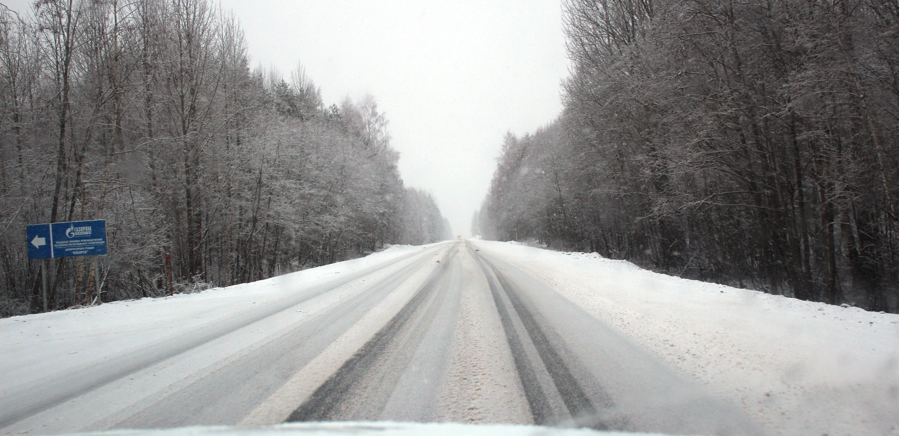 Подъезжая к городу начался. Заснеженная дорога. Зимняя трасса. Дорога зимой. Автомобильная дорога зимой.